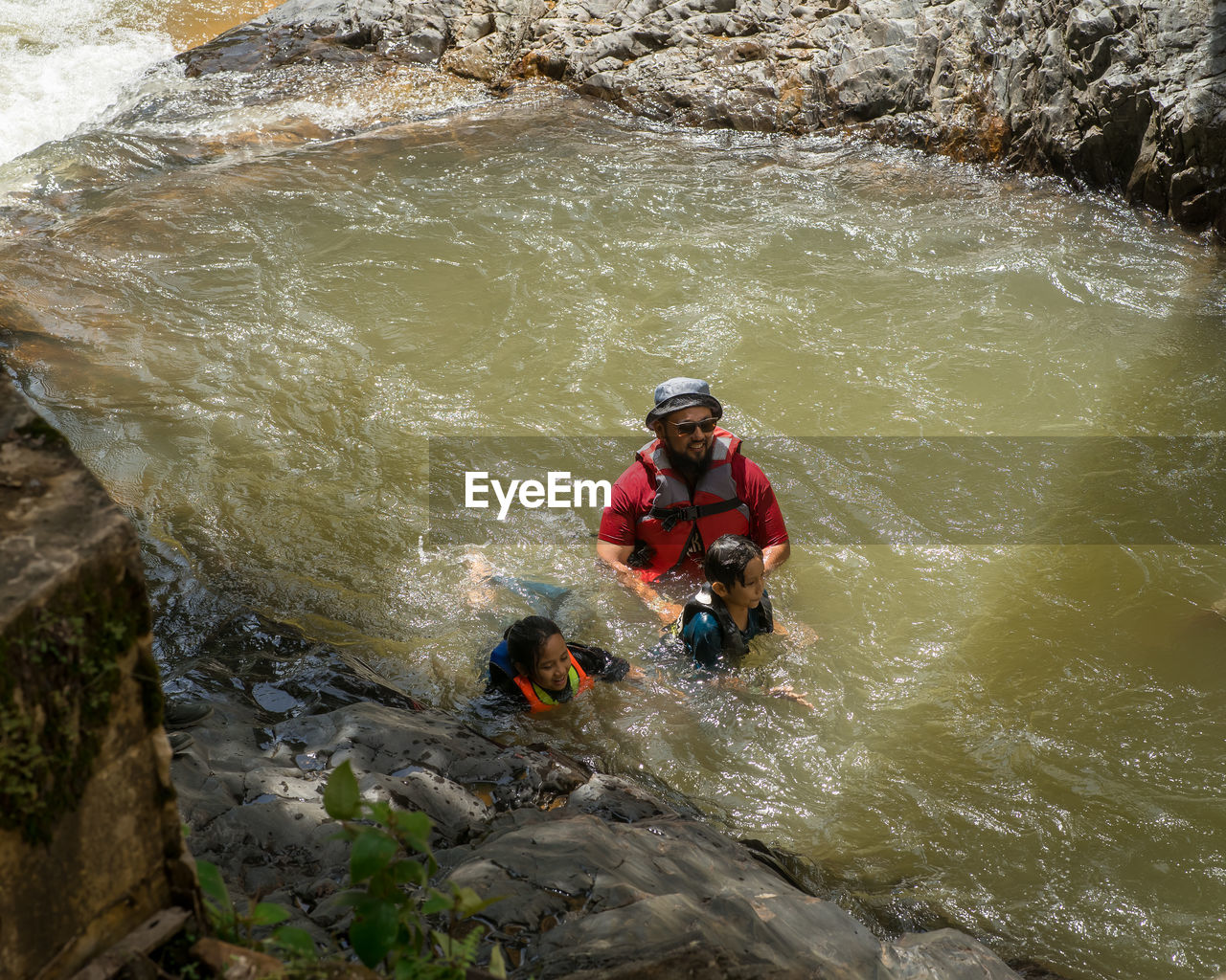 Asian family refreshing in the river in malaysia.