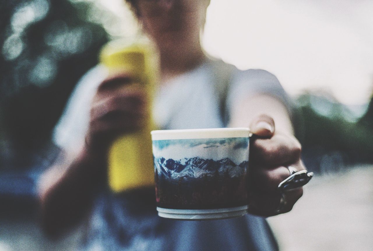 Midsection of woman holding cup