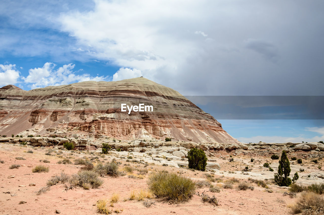 Scenic view of desert against cloudy sky