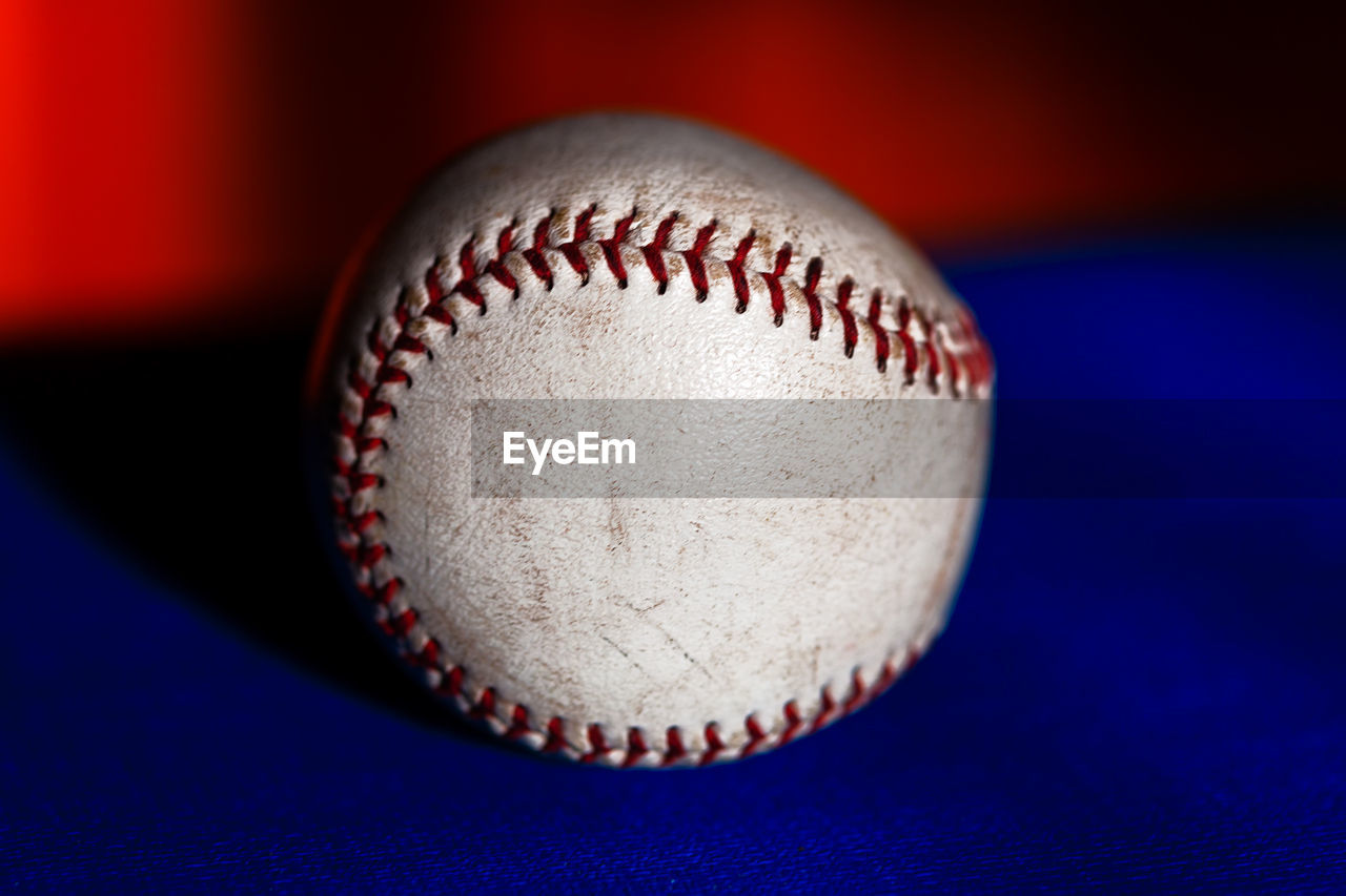 Baseball ball . blue and red background . sports leather ball sewn with thread