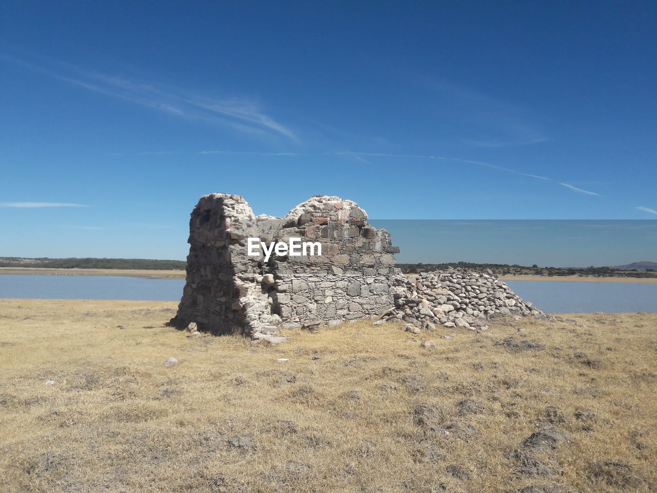 Rock formations on shore against blue sky