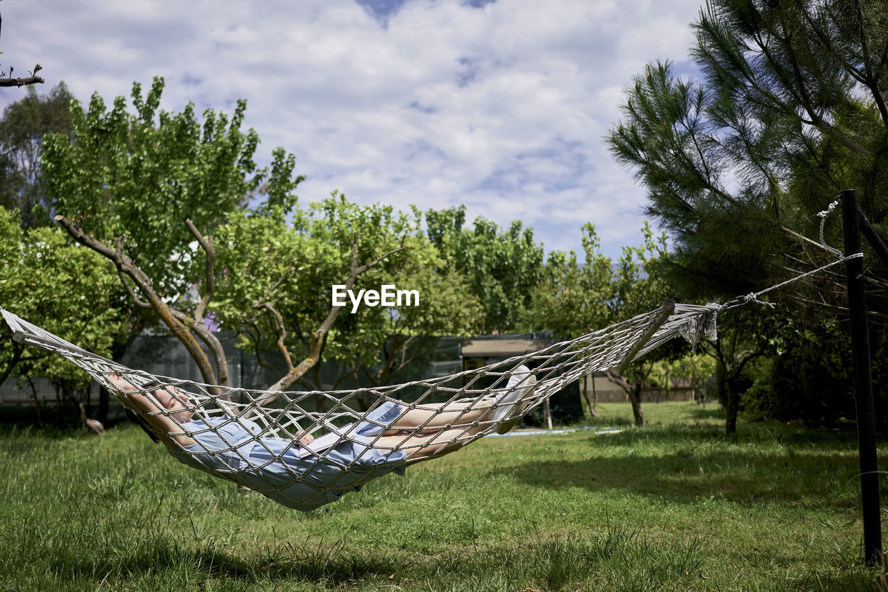 Woman relaxing on hammock in back yard