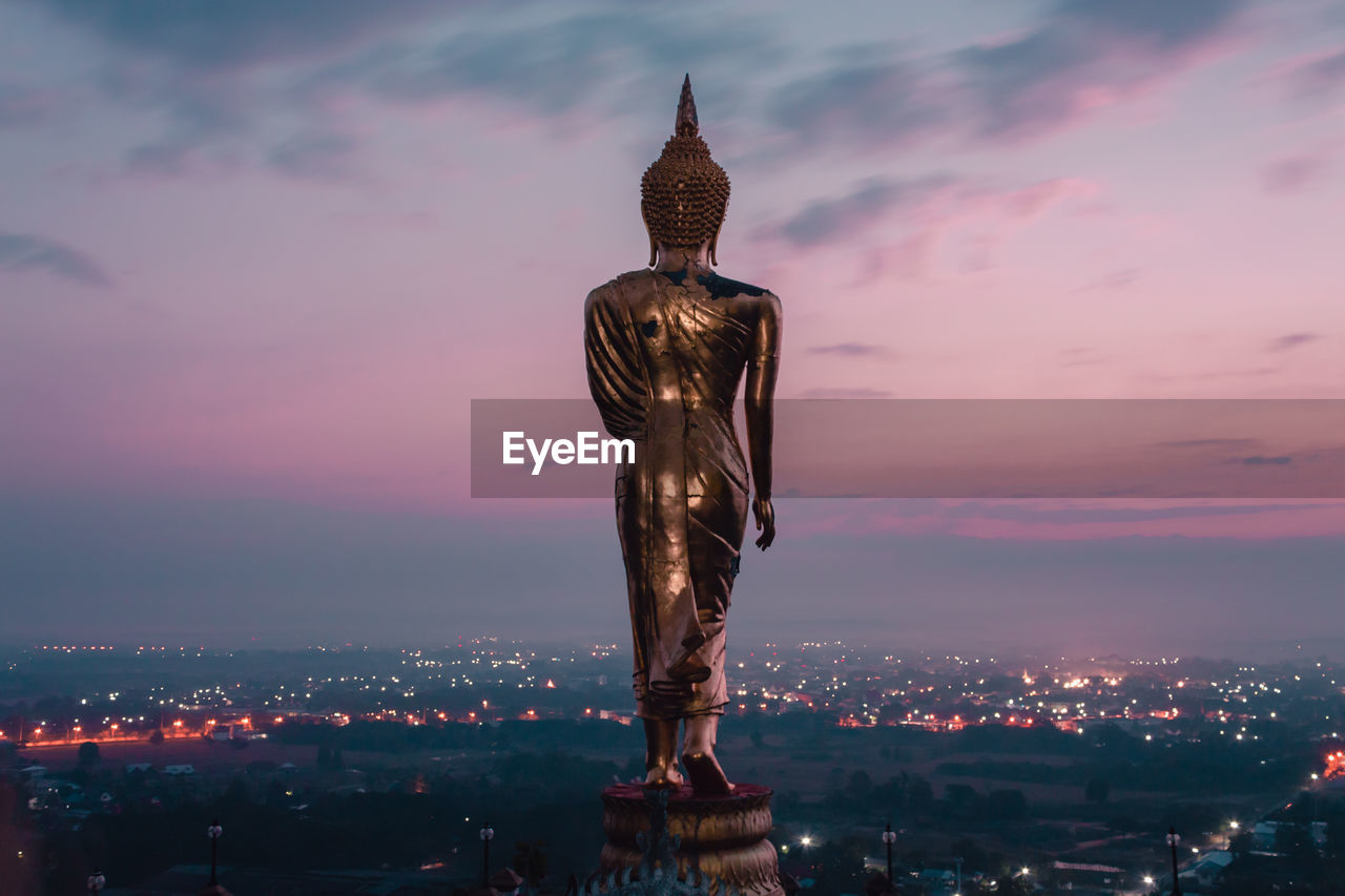 STATUE OF ILLUMINATED BUILDING IN CITY AT SUNSET