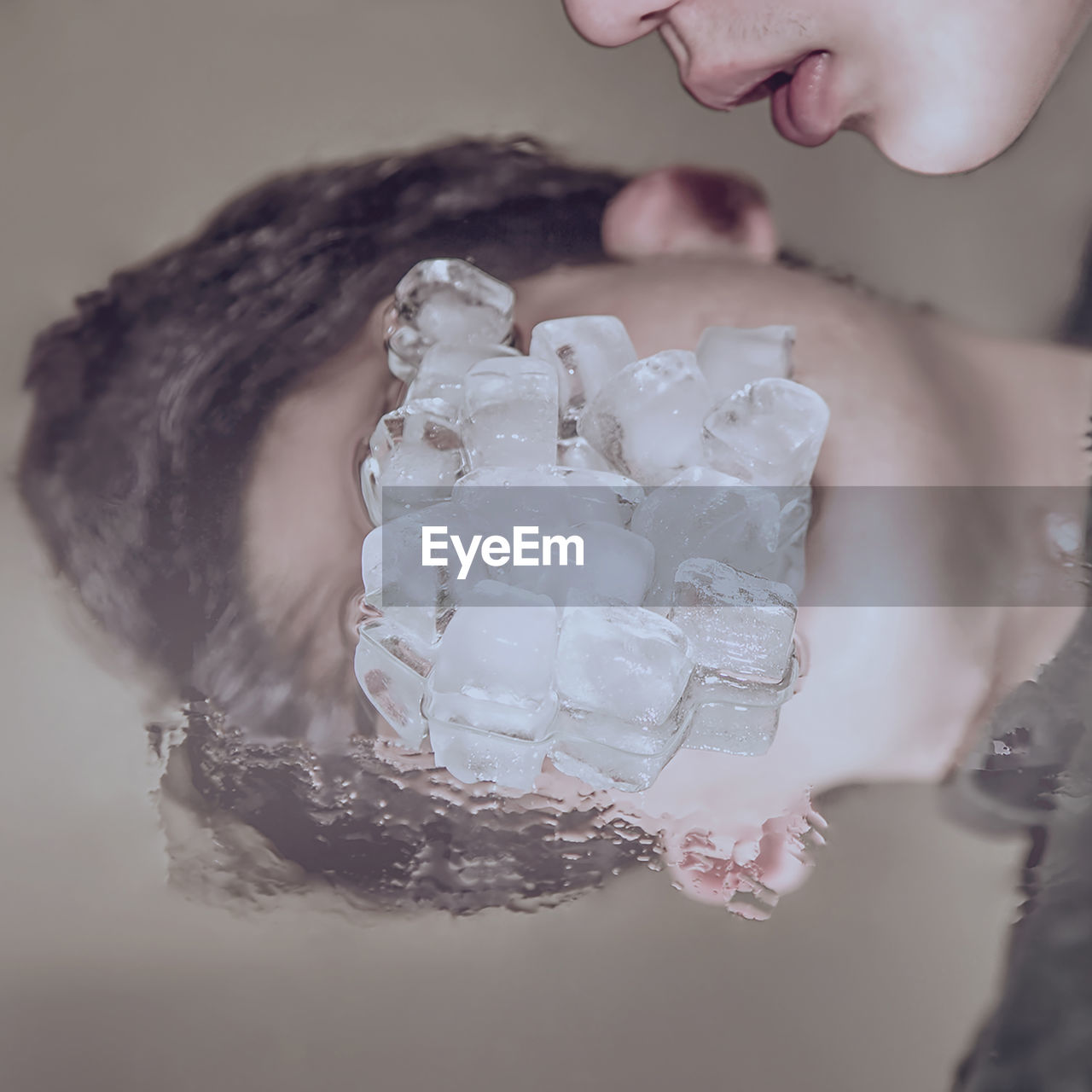 Cropped image of man with ice cubes on table