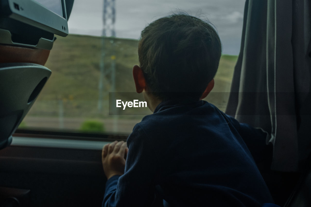 Boy looking through train window