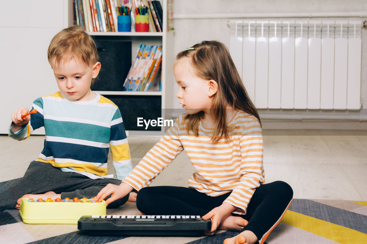 Child at home learning to play the piano. leisure and education at home