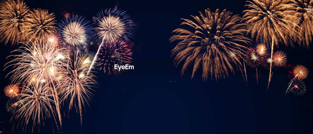 LOW ANGLE VIEW OF FIREWORKS DISPLAY AT NIGHT