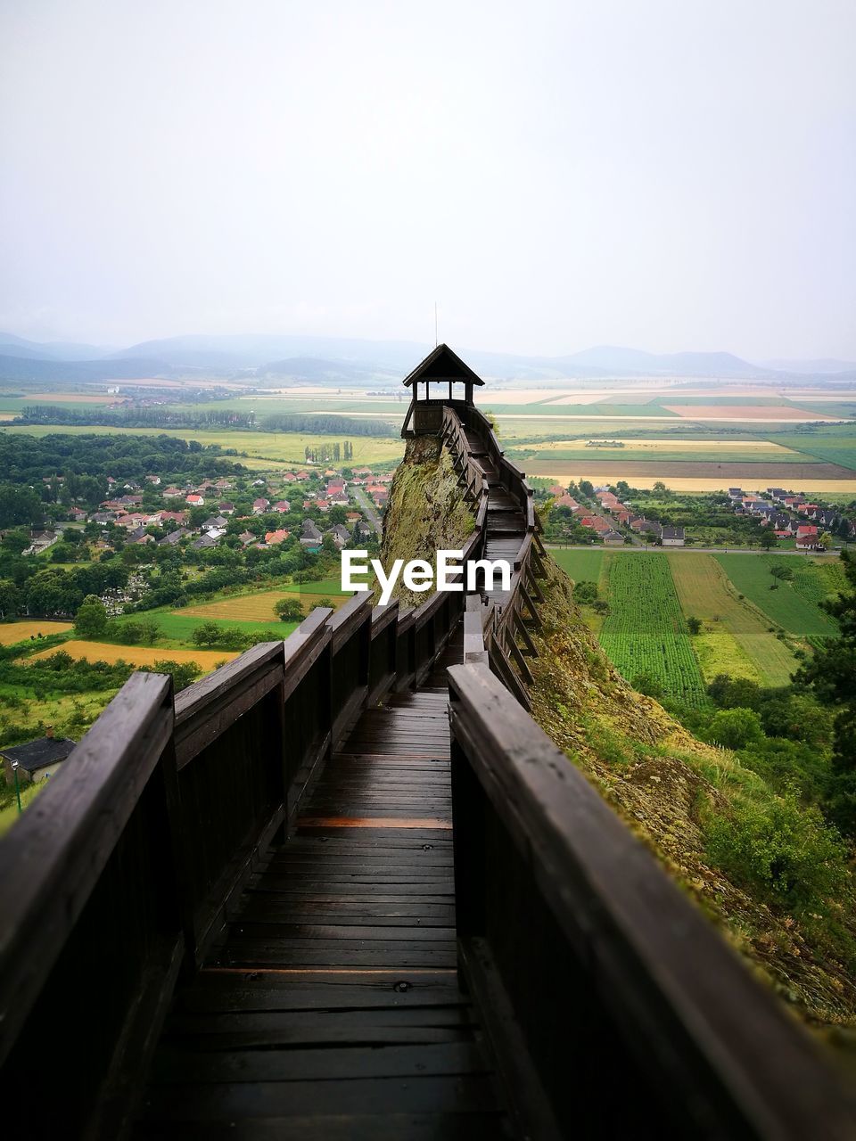 High angle view of walkway leading towards observation point by farms against clear sky