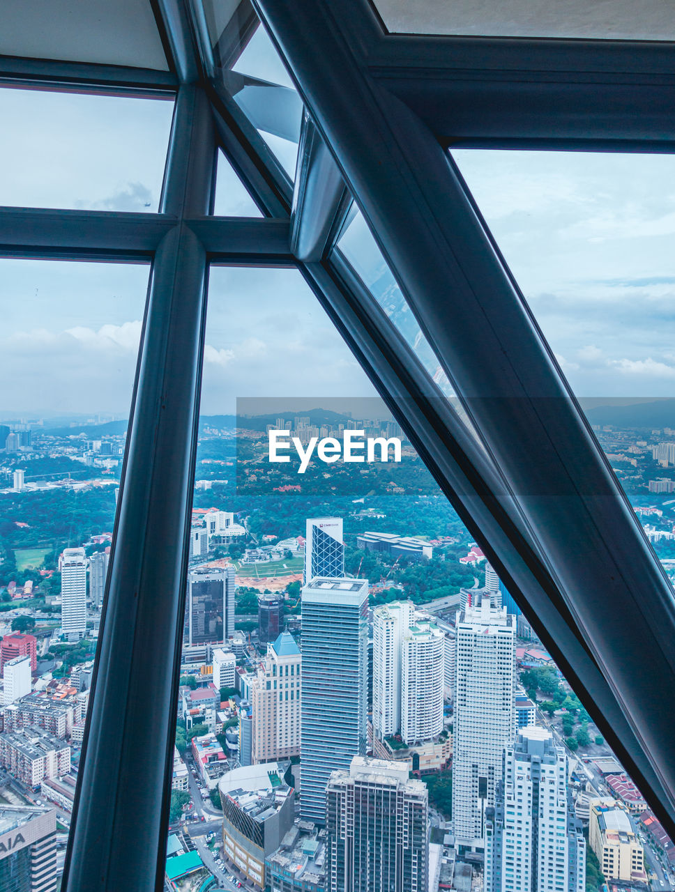 Cityscape of kuala lumpur against sky seen through window