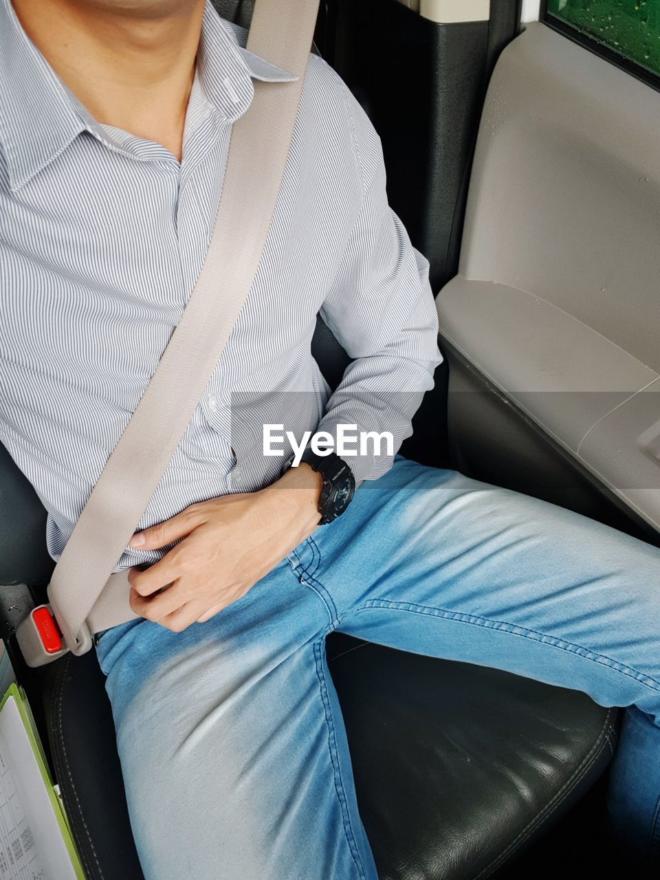 Midsection of man sitting on vehicle seat in car