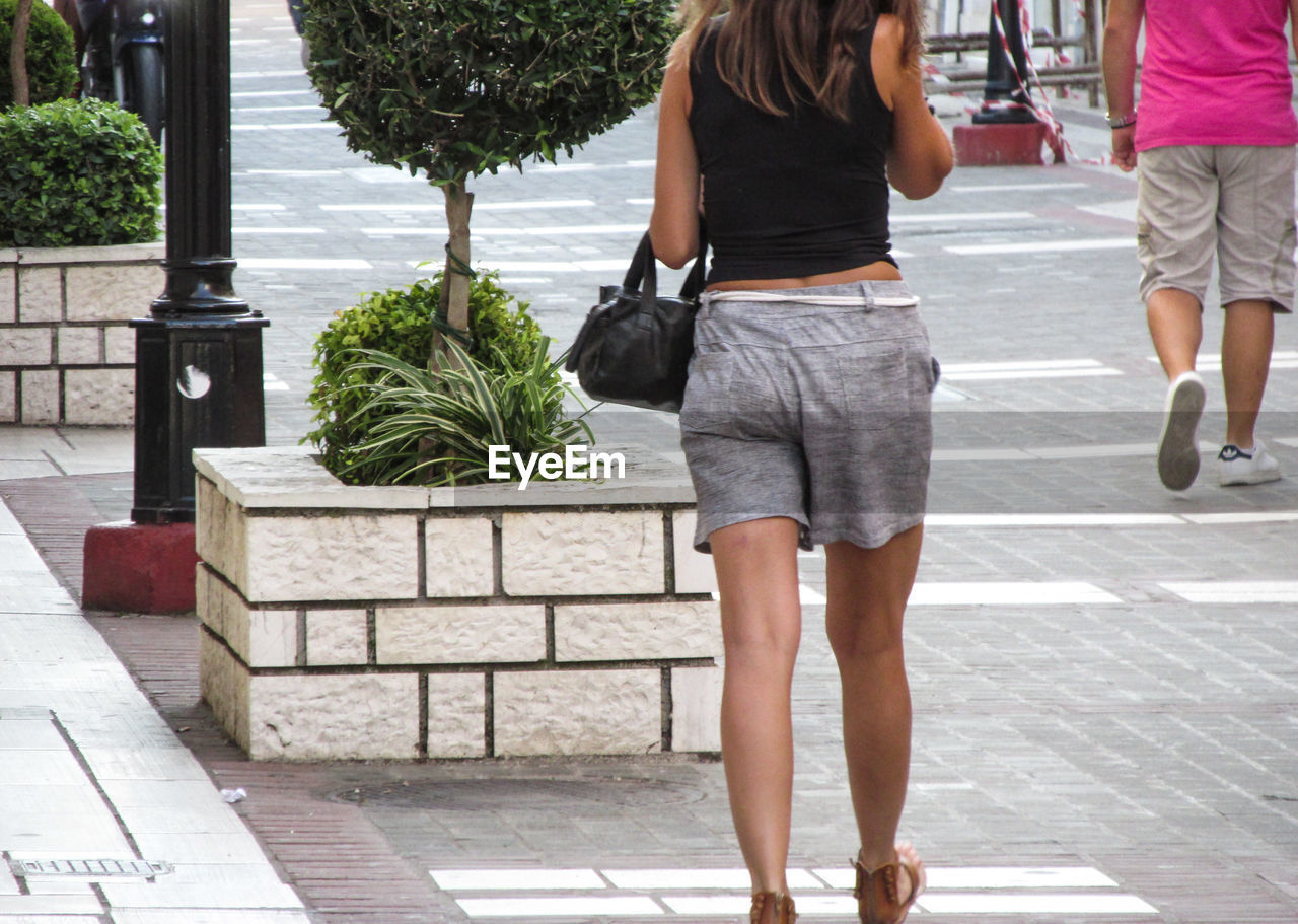 WOMAN WALKING ON SIDEWALK