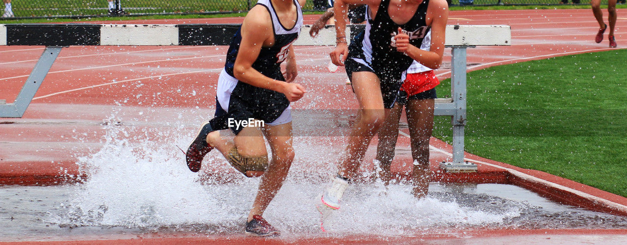sports, competition, motion, athlete, track and field event, competitive sport, group of people, lifestyles, running track, young adult, sports race, splashing, adult, clothing, vitality, endurance sports, sprinting, day, water, men, running, determination, sports clothing, player, nature, speed, outdoors, full length, jumping, women, strength, challenge, leisure activity, person, exercising