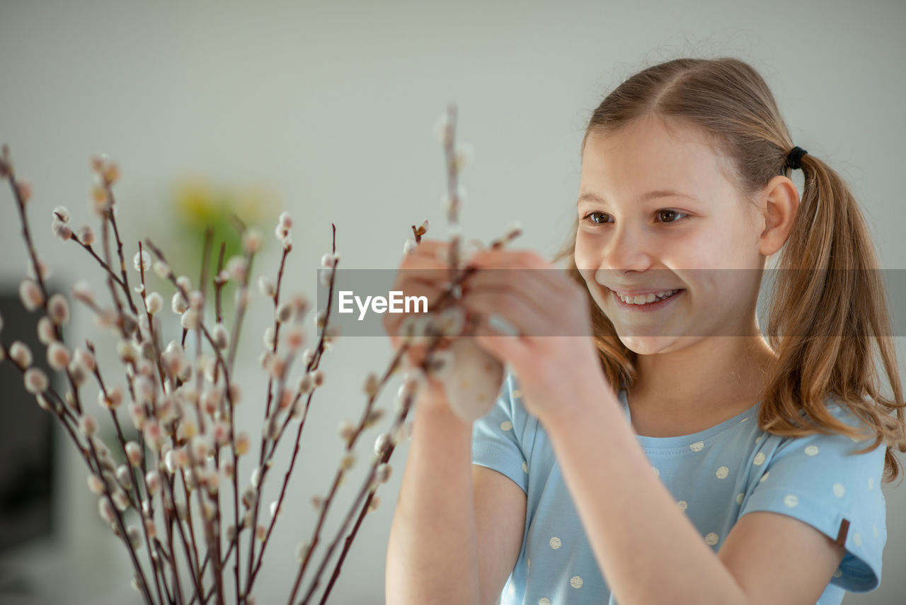 smiling, portrait, spring, child, childhood, one person, happiness, women, emotion, plant, female, cheerful, looking at camera, blond hair, nature, enjoyment, hairstyle, holding, positive emotion, indoors, casual clothing, lifestyles, headshot, flower, front view, portrait photography, teeth, smile, long hair, cute, growth, fun, person, waist up, adult