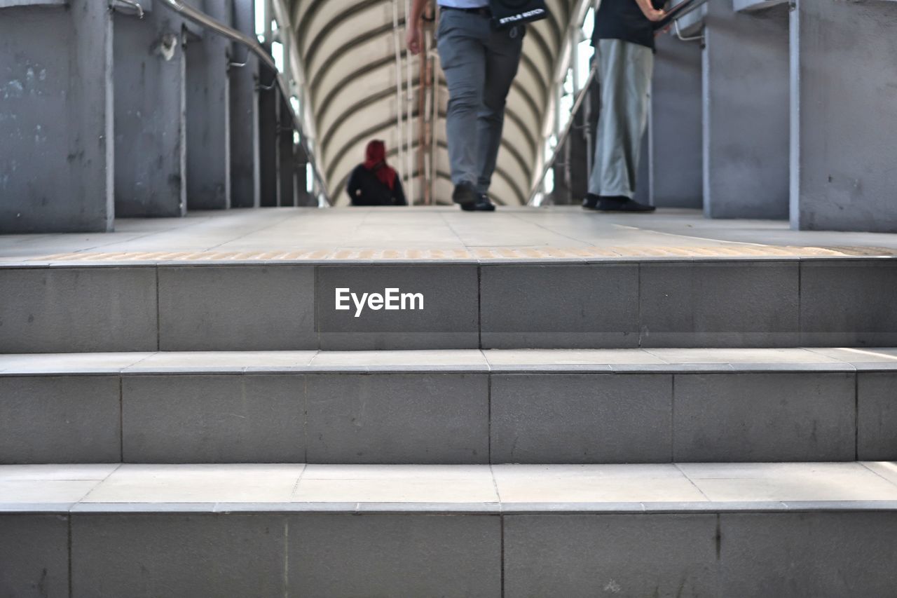 LOW SECTION OF PEOPLE WALKING ON STAIRS