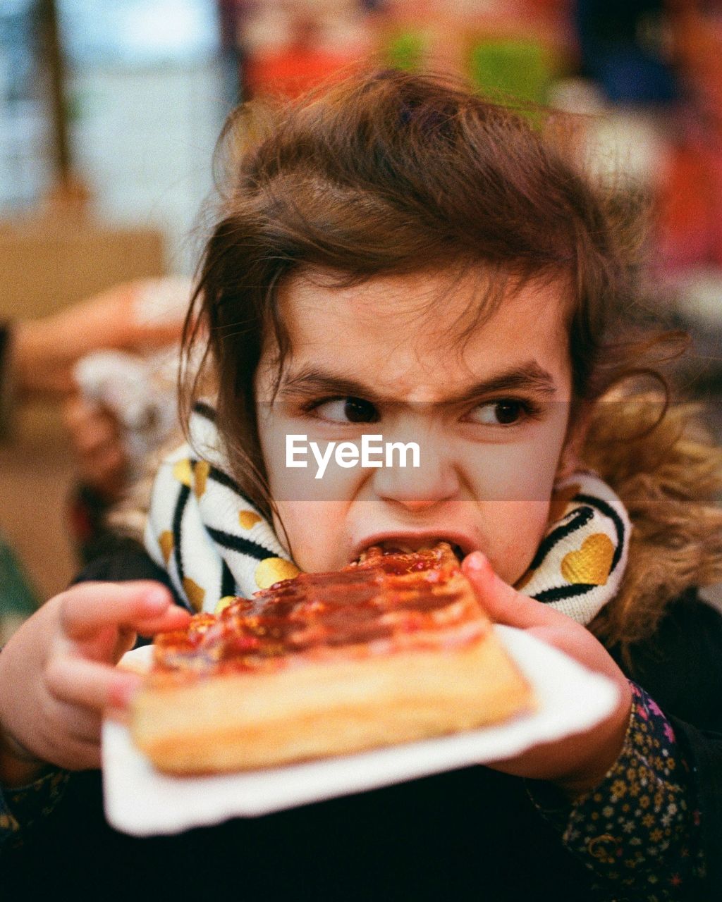 Close-up of girl looking away while eating waffle