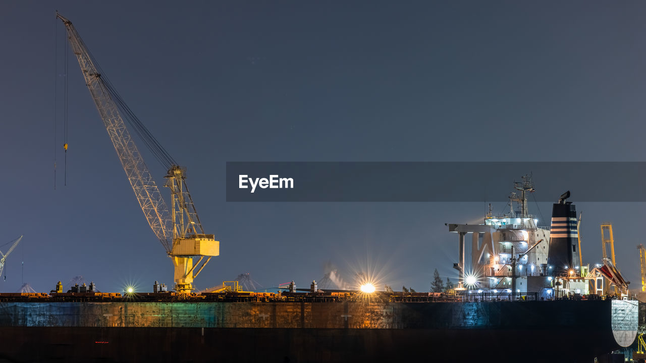 Container oil ship repair in shipyard at night. can use for shipping or transportation concept.