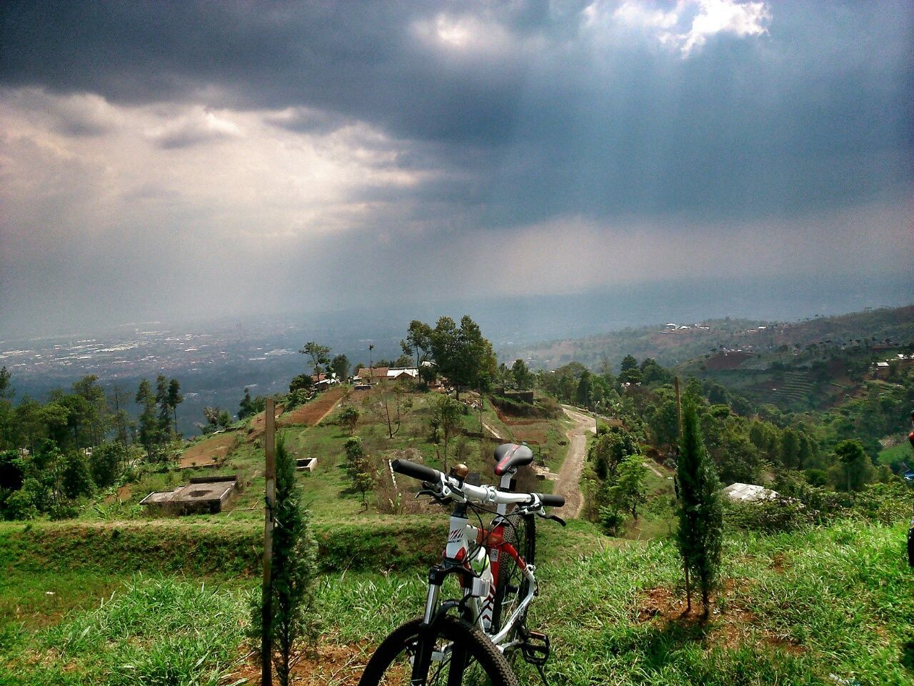 Mountain bike on landscape against cloudy sky