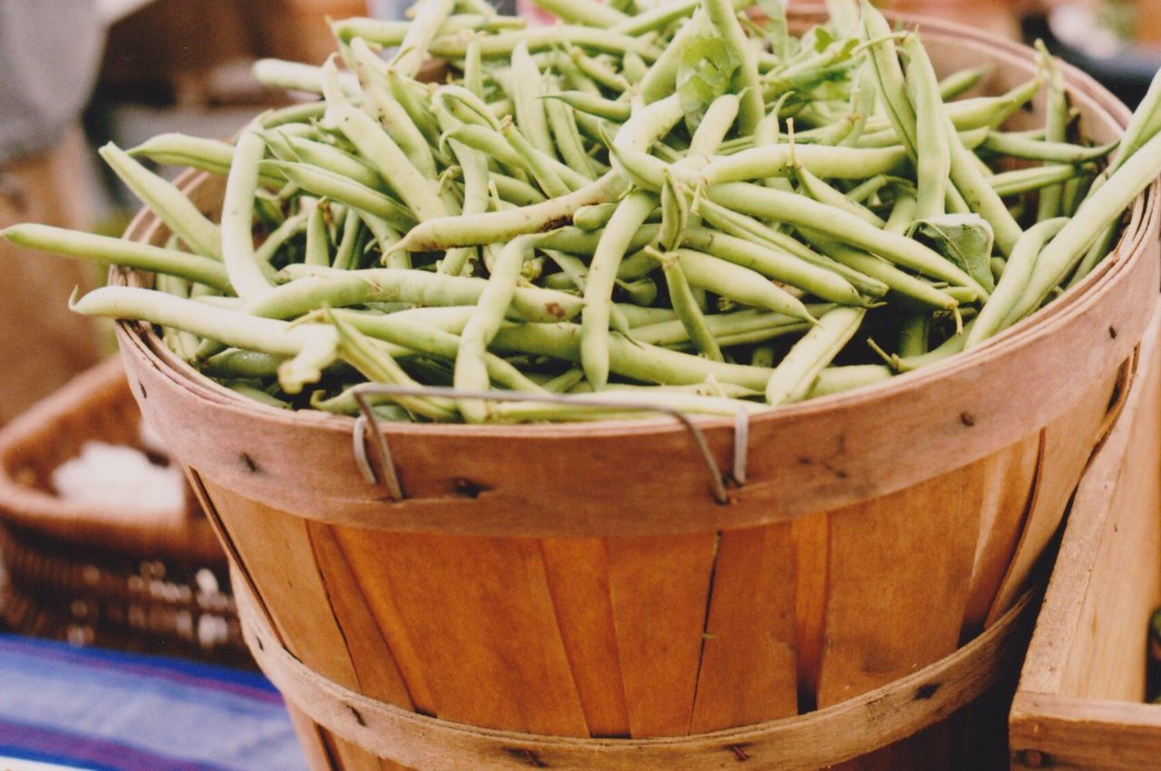 Green beans in bucket for sale at market stall