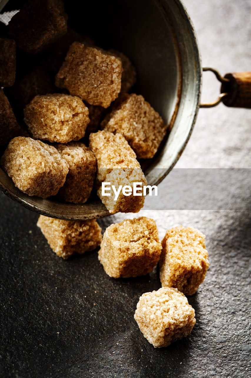 Brown organic sugar cubes close-up on dark background, selective focus