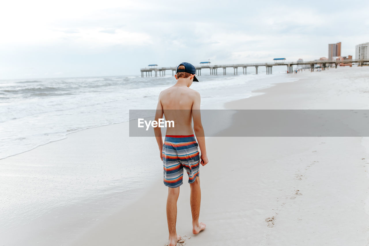 Full length of teenage boy walking on beach