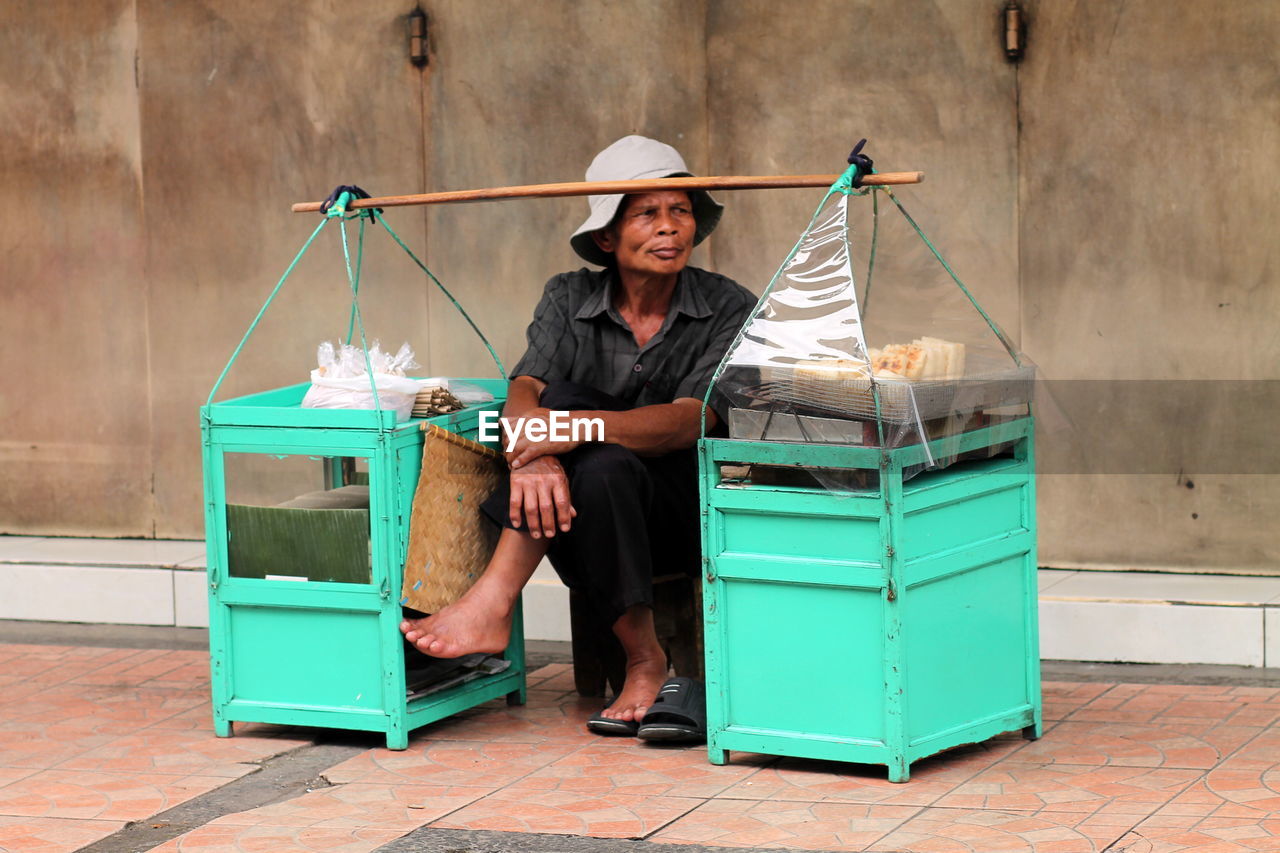 View of a man selling snack on the side  walk.