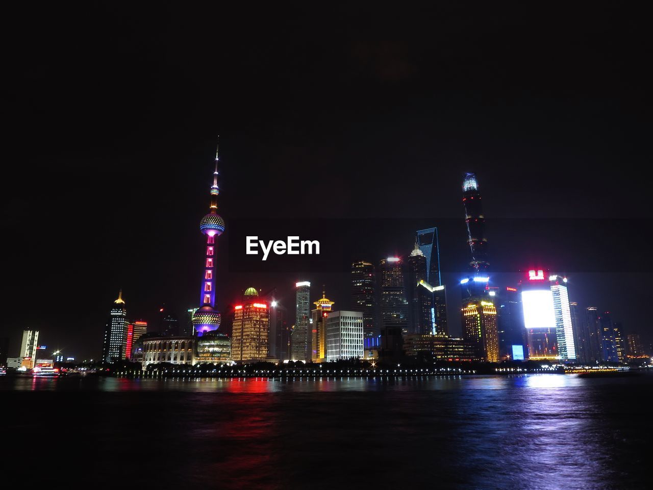 ILLUMINATED CITY AT WATERFRONT