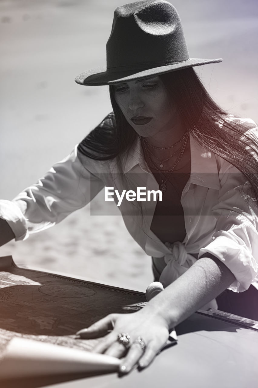 white, adult, fedora, one person, hat, women, clothing, black, fashion accessory, person, sun hat, cowboy hat, lifestyles, young adult, monochrome, sitting, black and white, female, nature, leisure activity, fashion, monochrome photography, casual clothing, day, glasses, photo shoot, outdoors, relaxation, sunlight, long hair, emotion