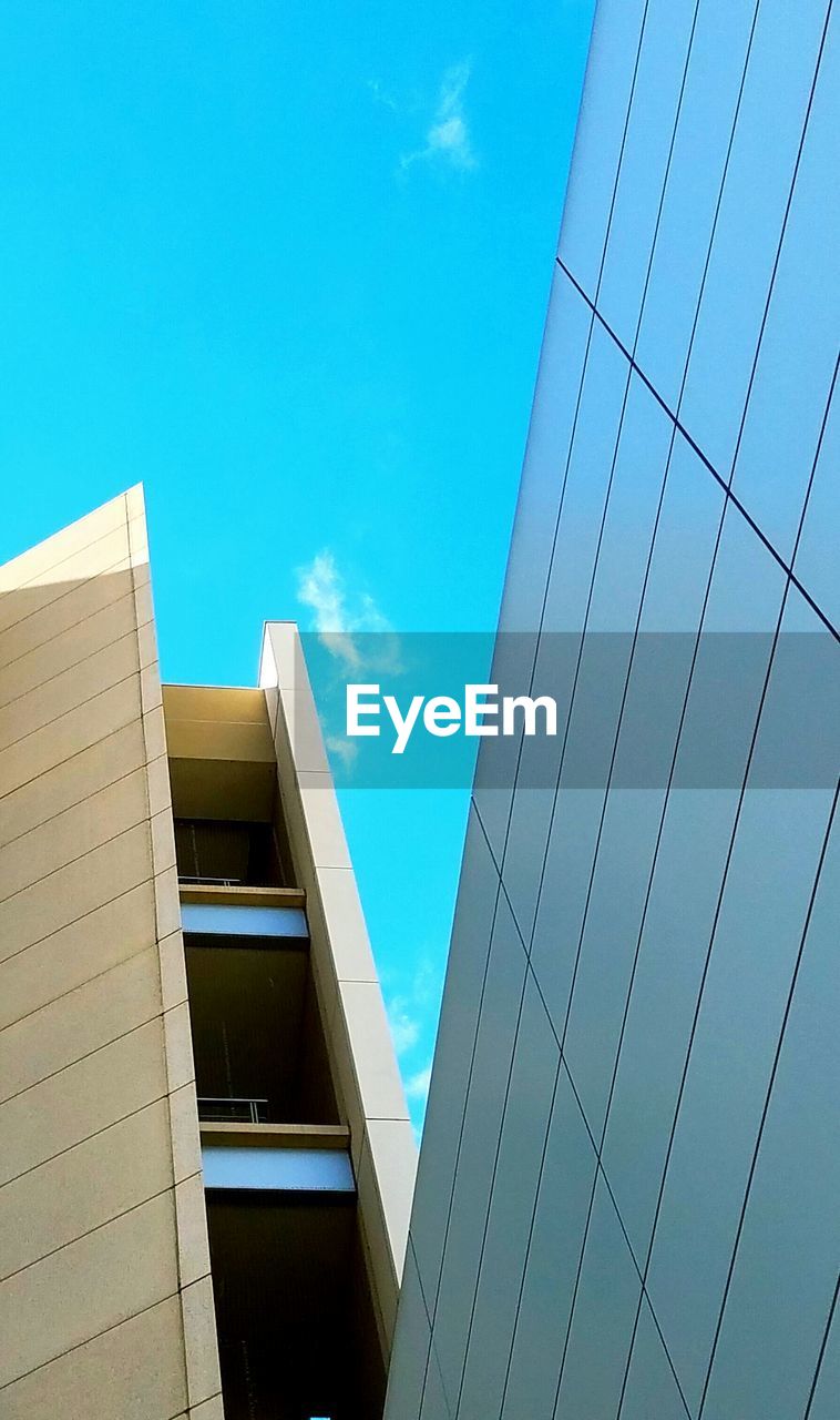 LOW ANGLE VIEW OF OFFICE BUILDING AGAINST BLUE SKY