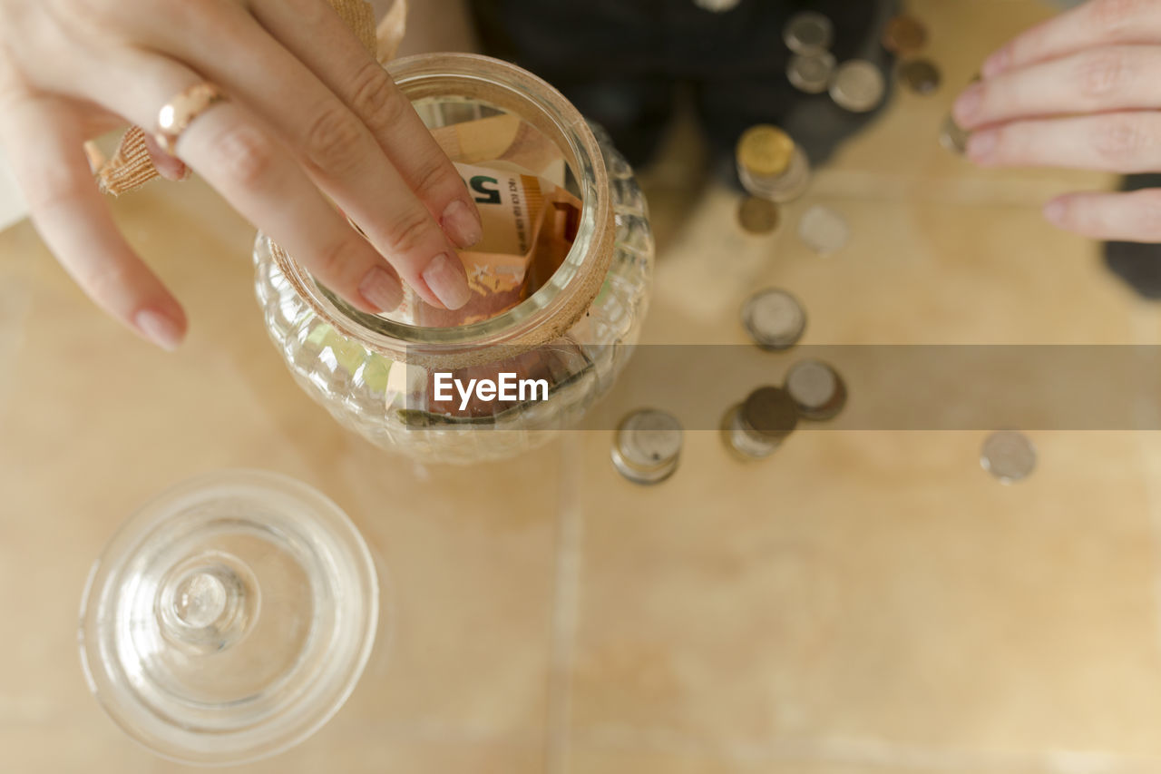 Hand of man and woman counting currency on table at home