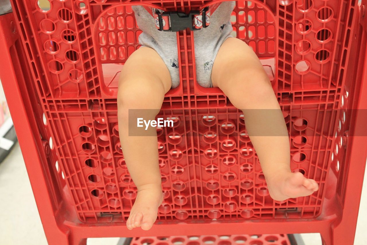 Low section of baby sitting in shopping cart