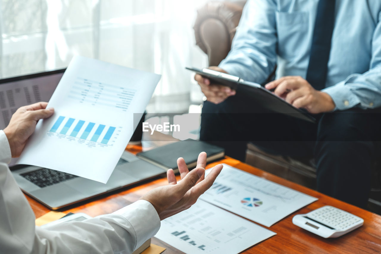 Cropped image of business colleagues working at desk in office