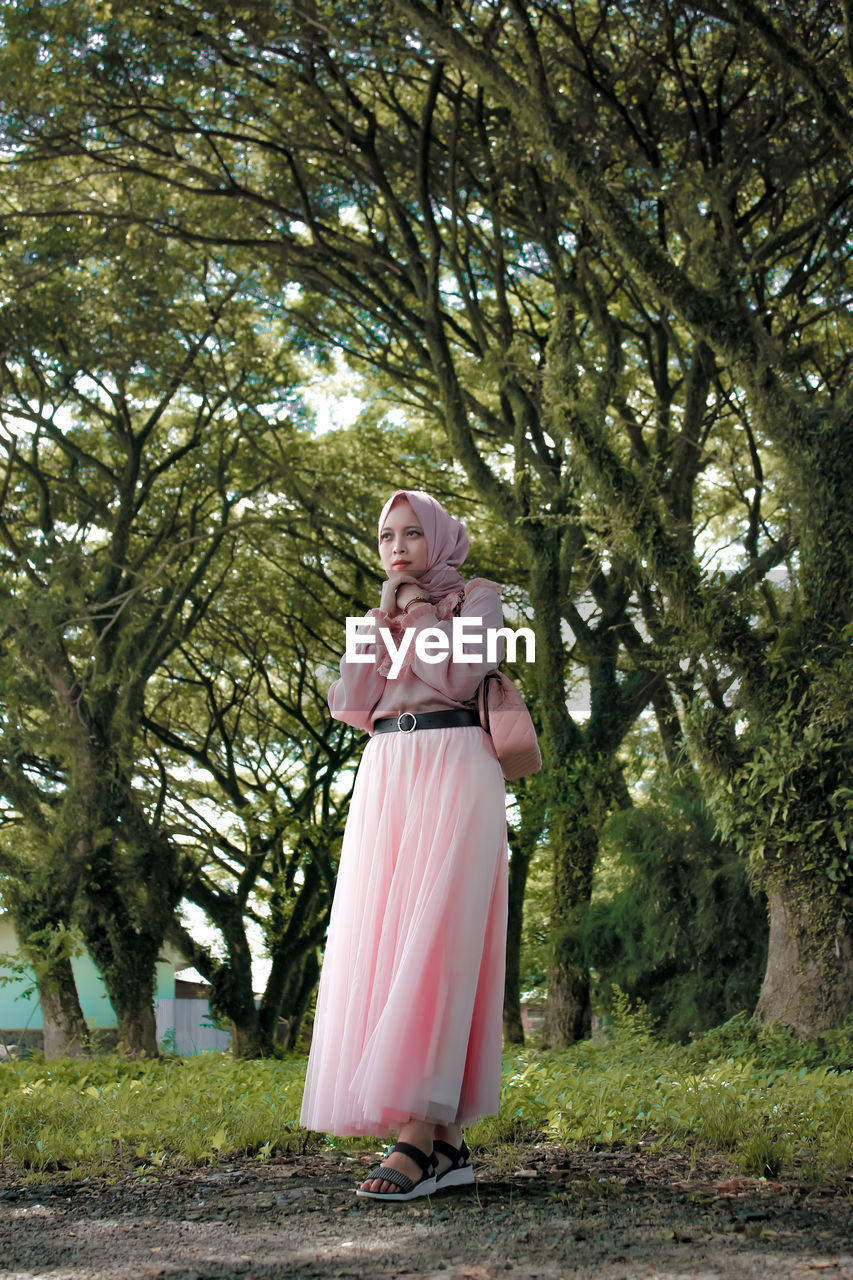 Woman standing by tree in park