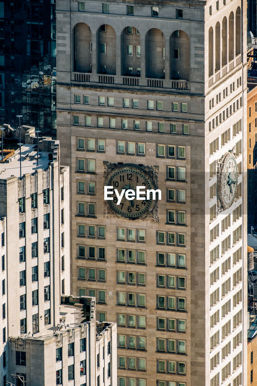 LOW ANGLE VIEW OF CLOCK TOWER AGAINST BUILDING