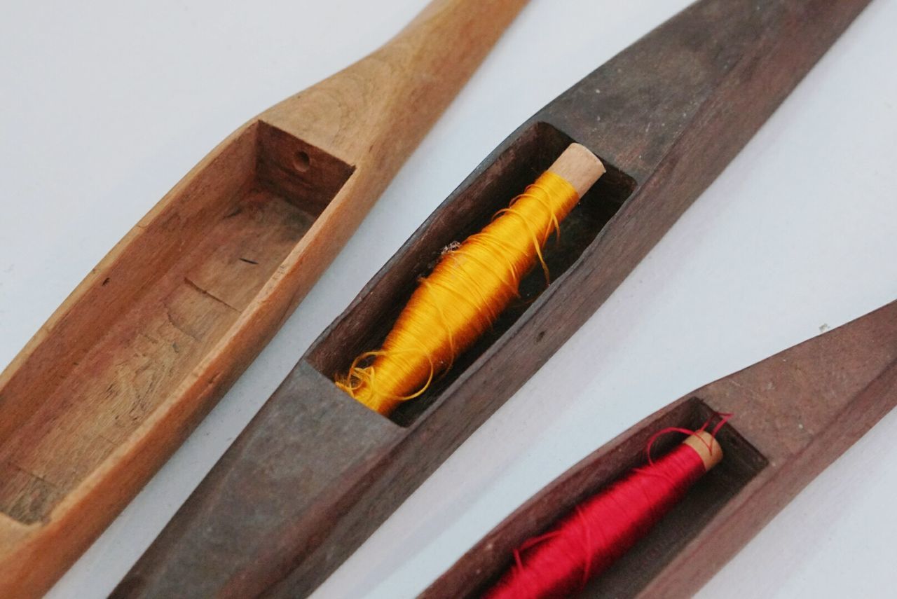 High angle view of thread spools in wooden containers on table