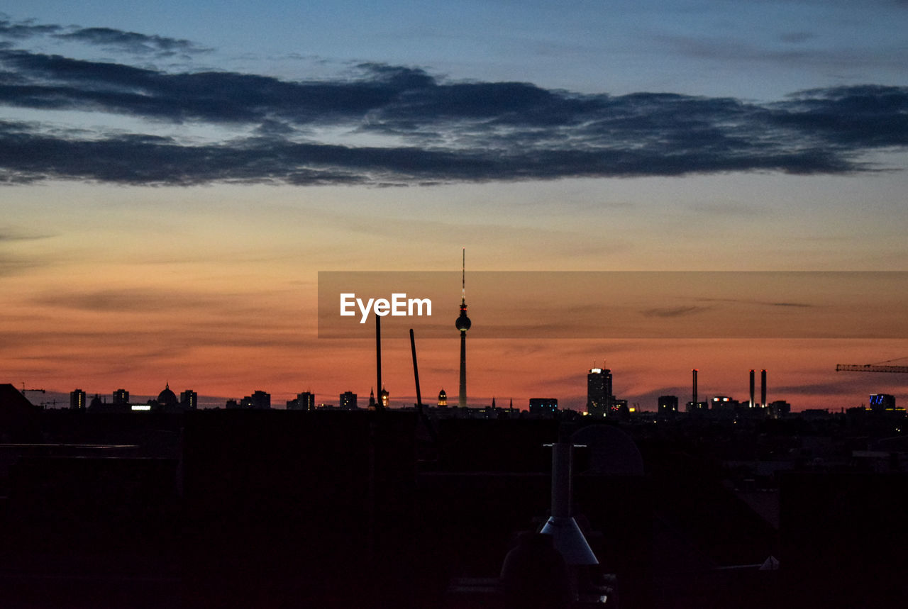 Silhouette buildings against sky during sunset