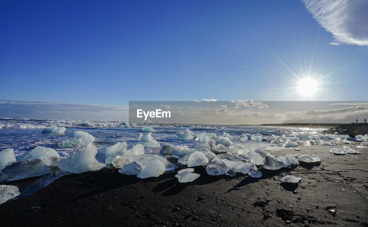 Snow covered land against blue sky