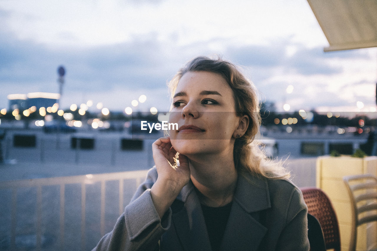 Young woman looking away in city at night