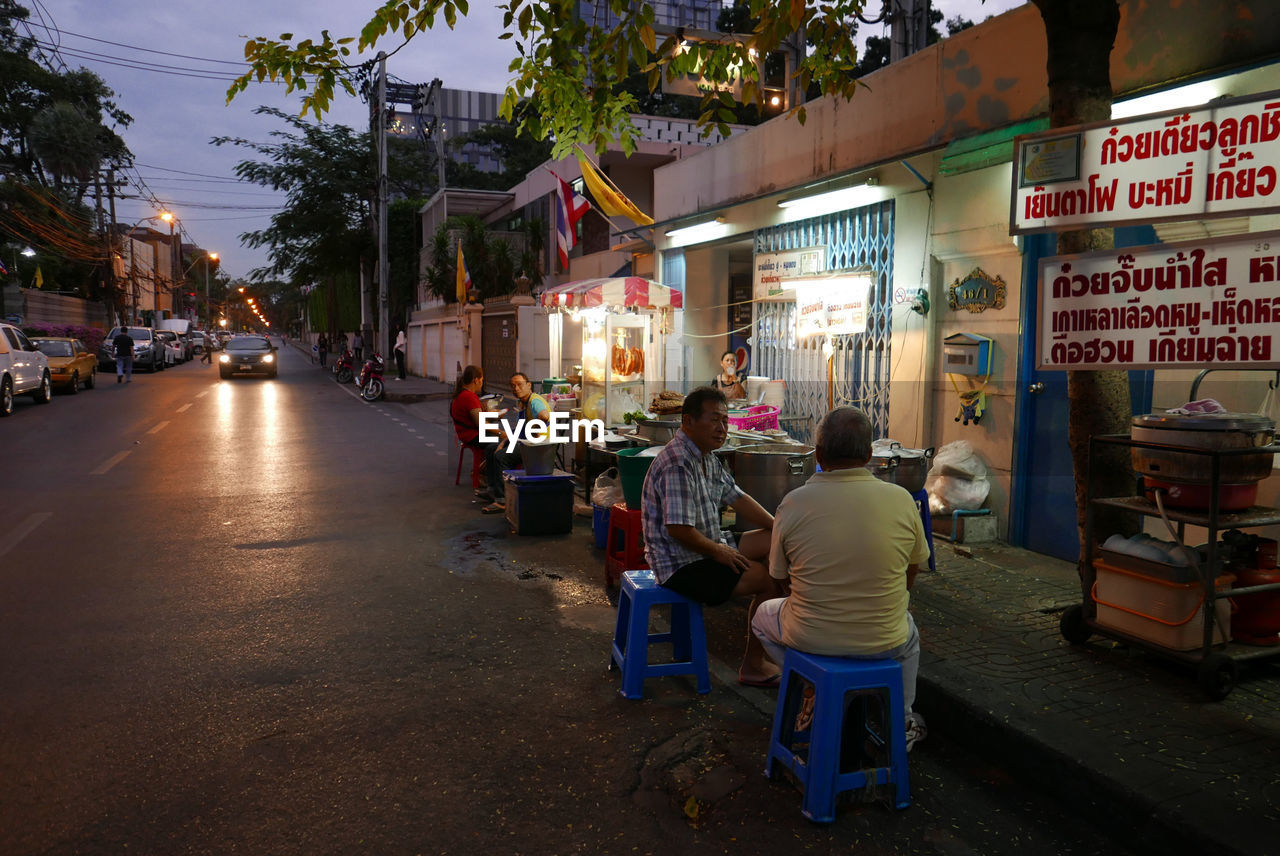 People sitting on street at dusk