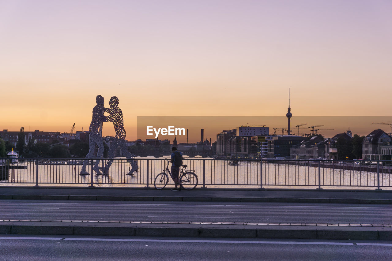 PEOPLE ON BRIDGE AT RIVERBANK