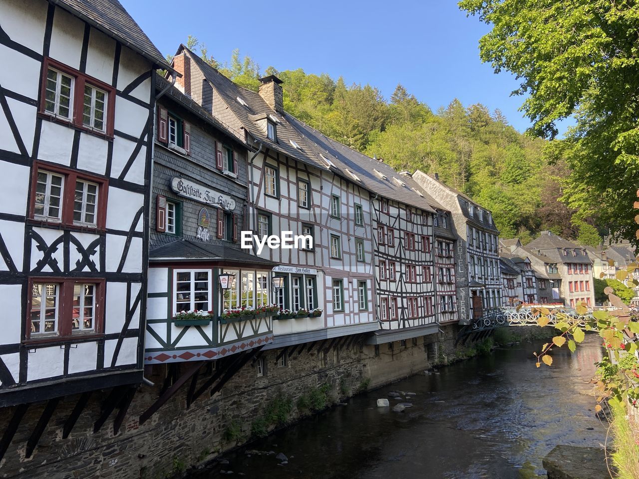 Houses by river against sky