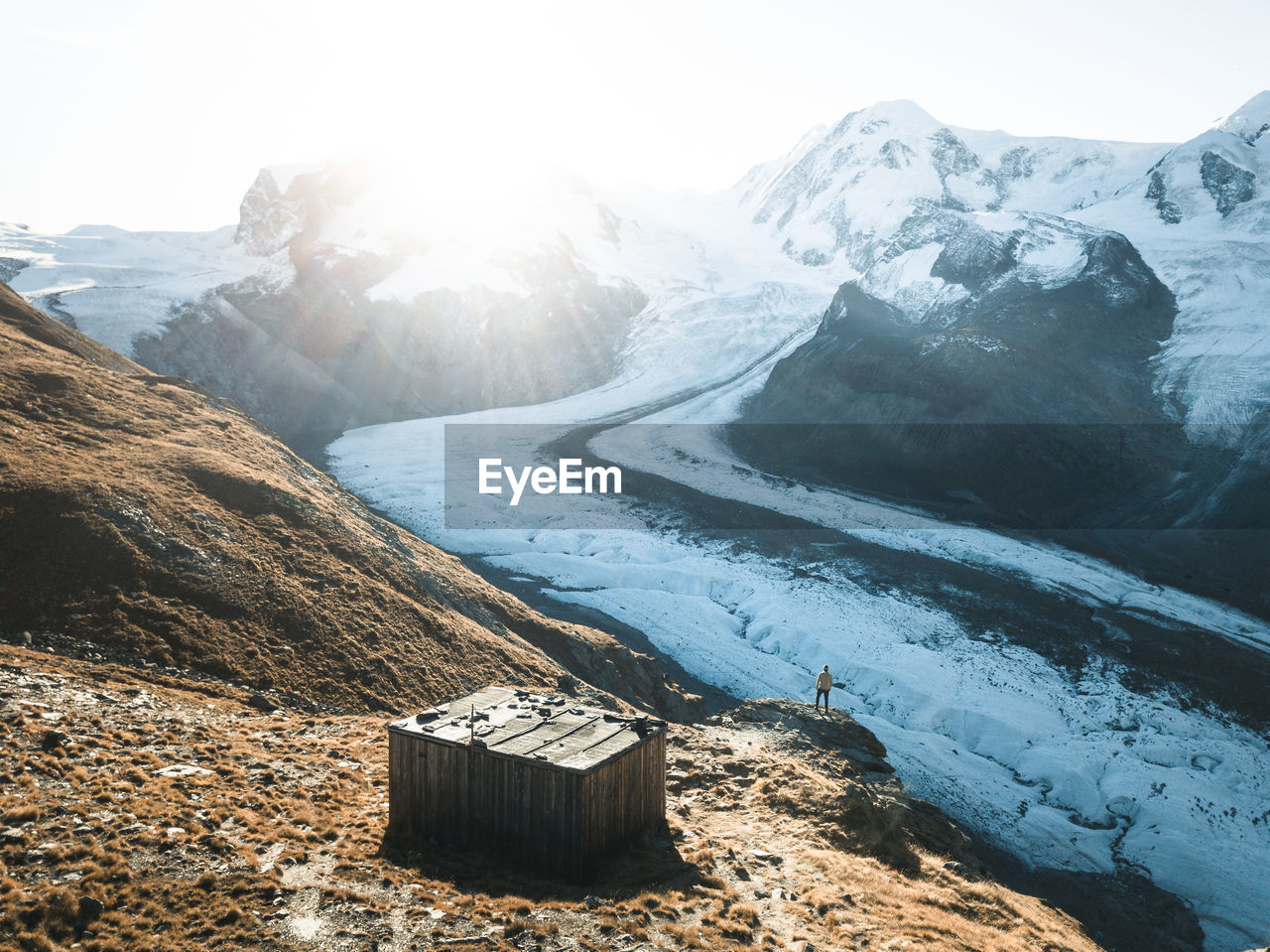 A hiker watching the sun come up over the gorner glacier near zermatt, switzerland.