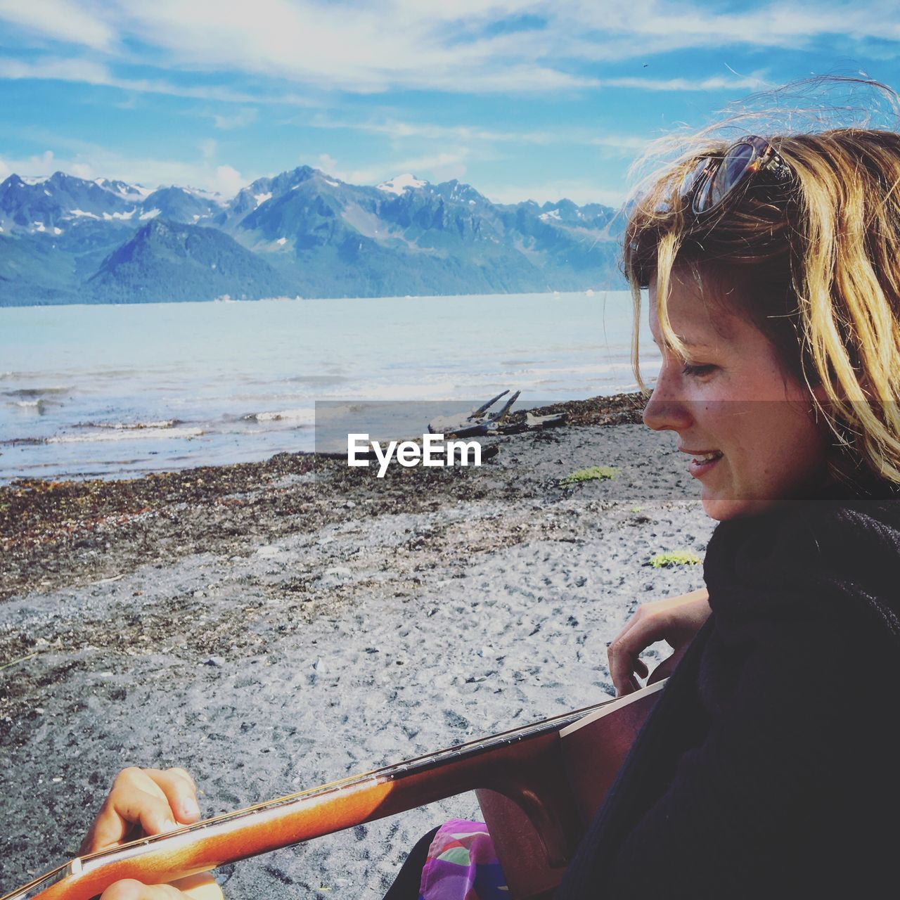 Woman playing guitar on beach