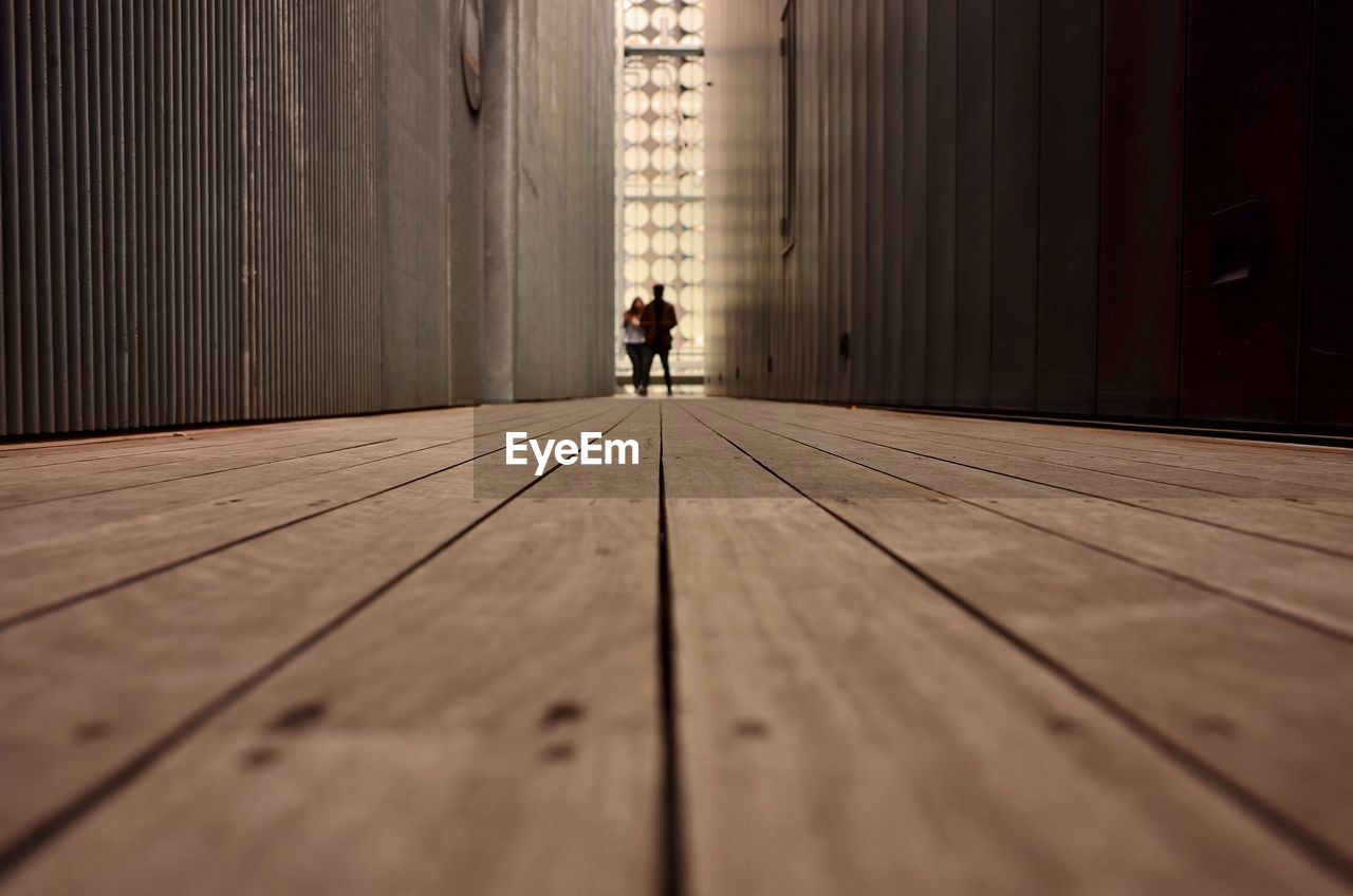 Surface level view of people standing boardwalk amidst buildings