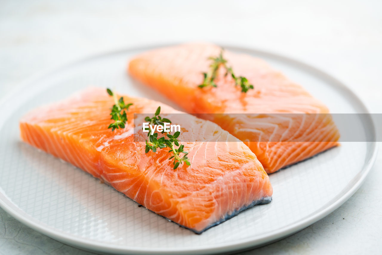 Fresh salmon fillet with herbs on a plate for delicious salmon steak.