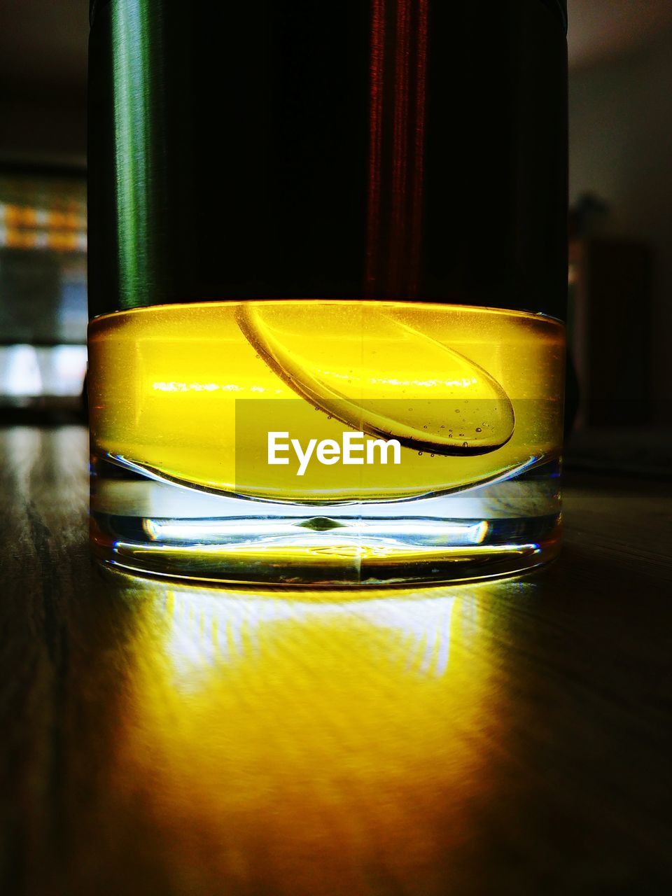 CLOSE-UP OF YELLOW GLASS ON TABLE