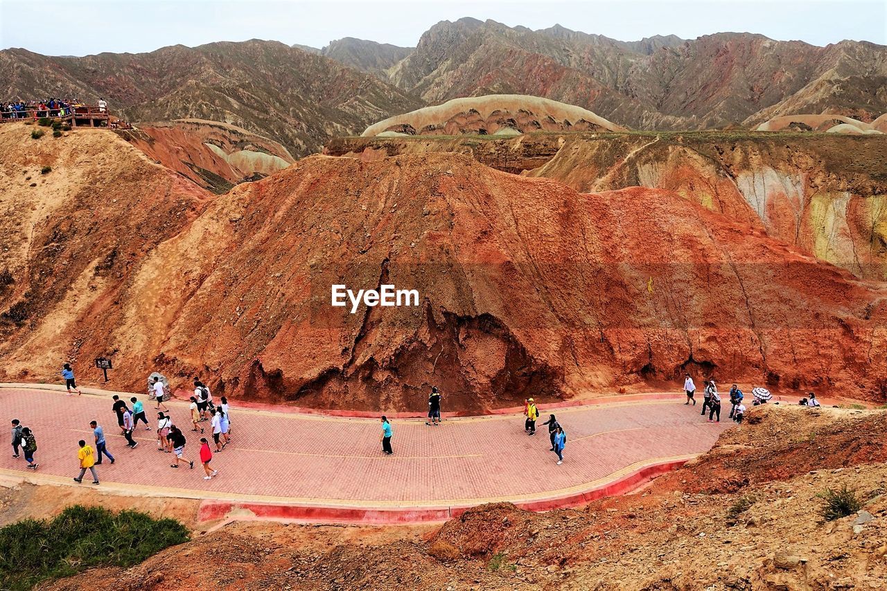 Group of people on road by rock formation