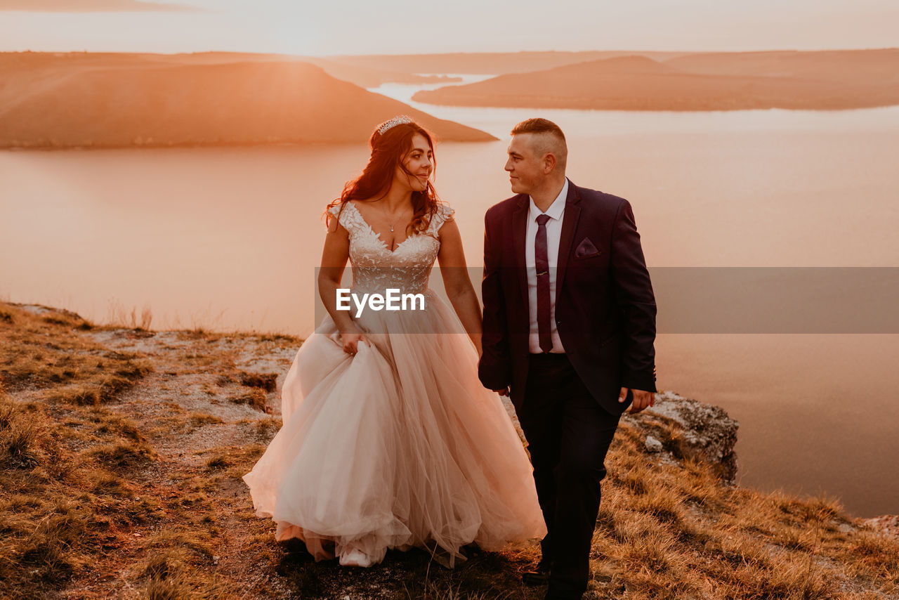 portrait of smiling couple standing on rock