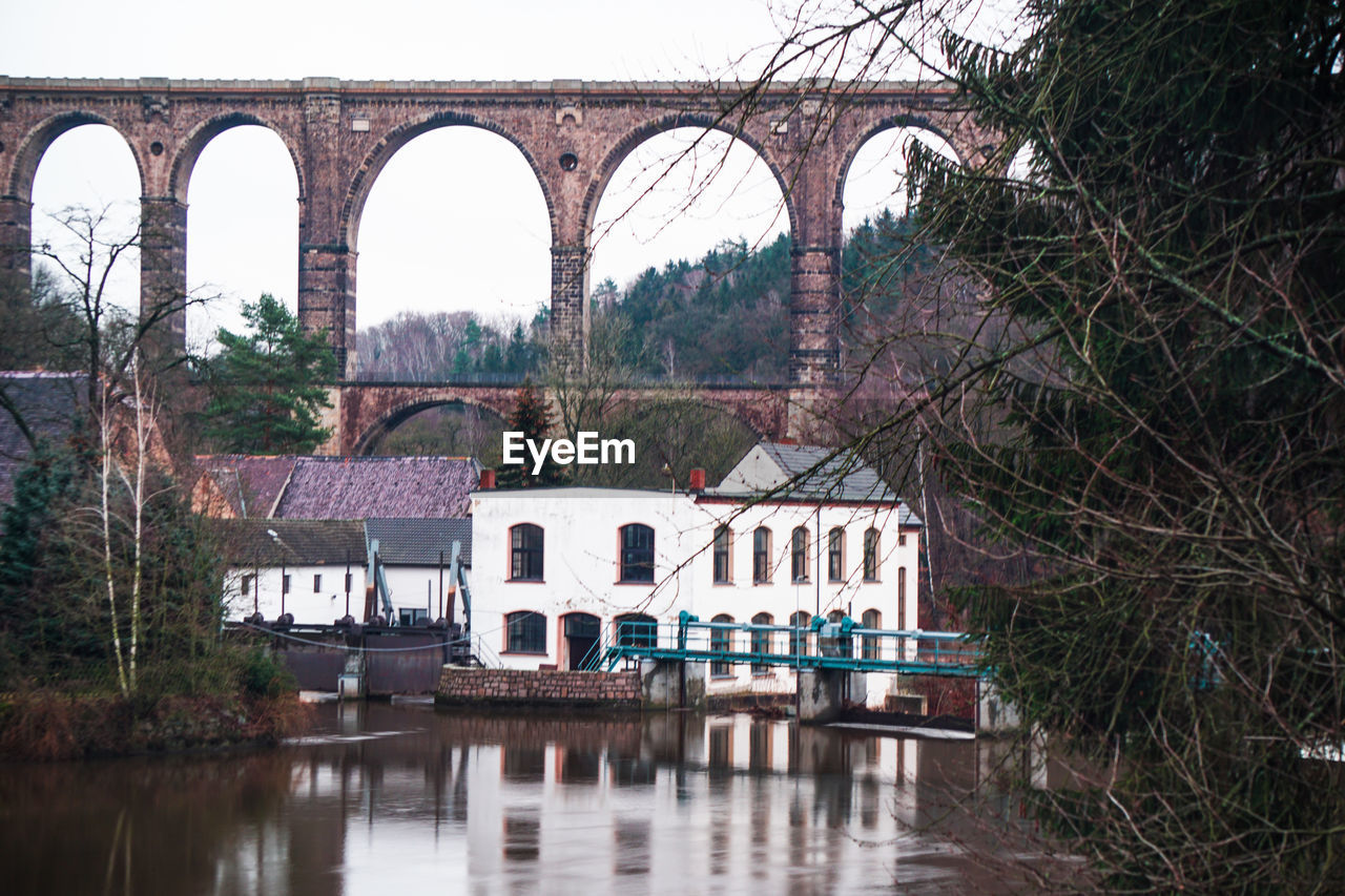 BRIDGE OVER RIVER AGAINST TREES