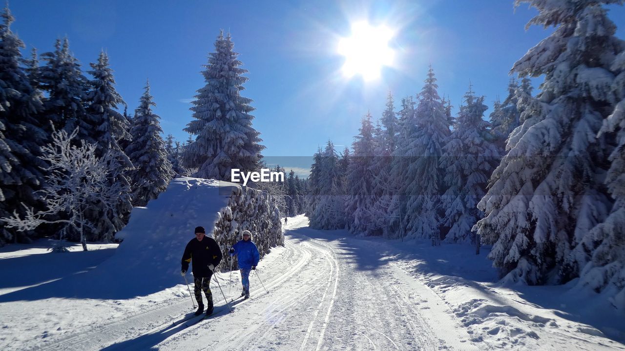 PEOPLE ON SNOW COVERED LANDSCAPE AGAINST SKY