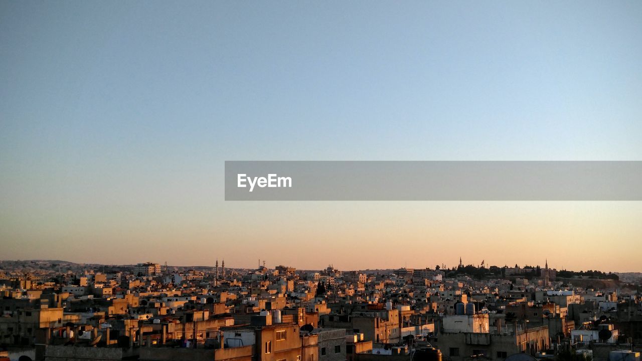 High angle view of buildings against clear sky at sunset